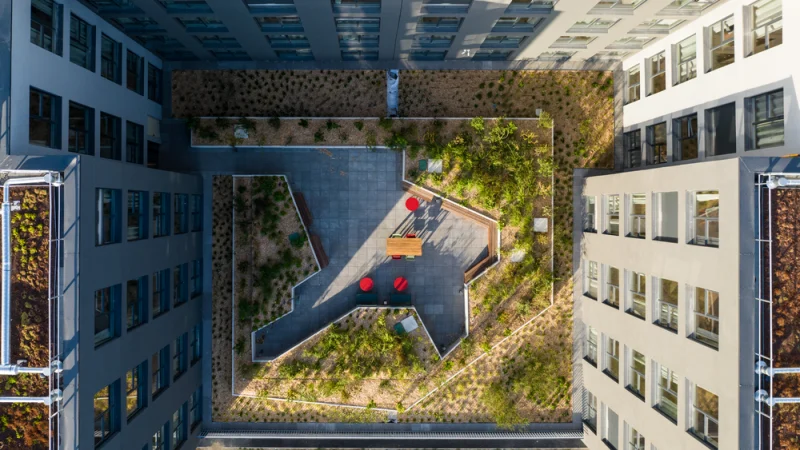 Espacios verdes en edificación residencial sostenible moderna Vista aérea de maquinaria extendiendo asfalto sostenible en una carretera en España para su conservación viaria